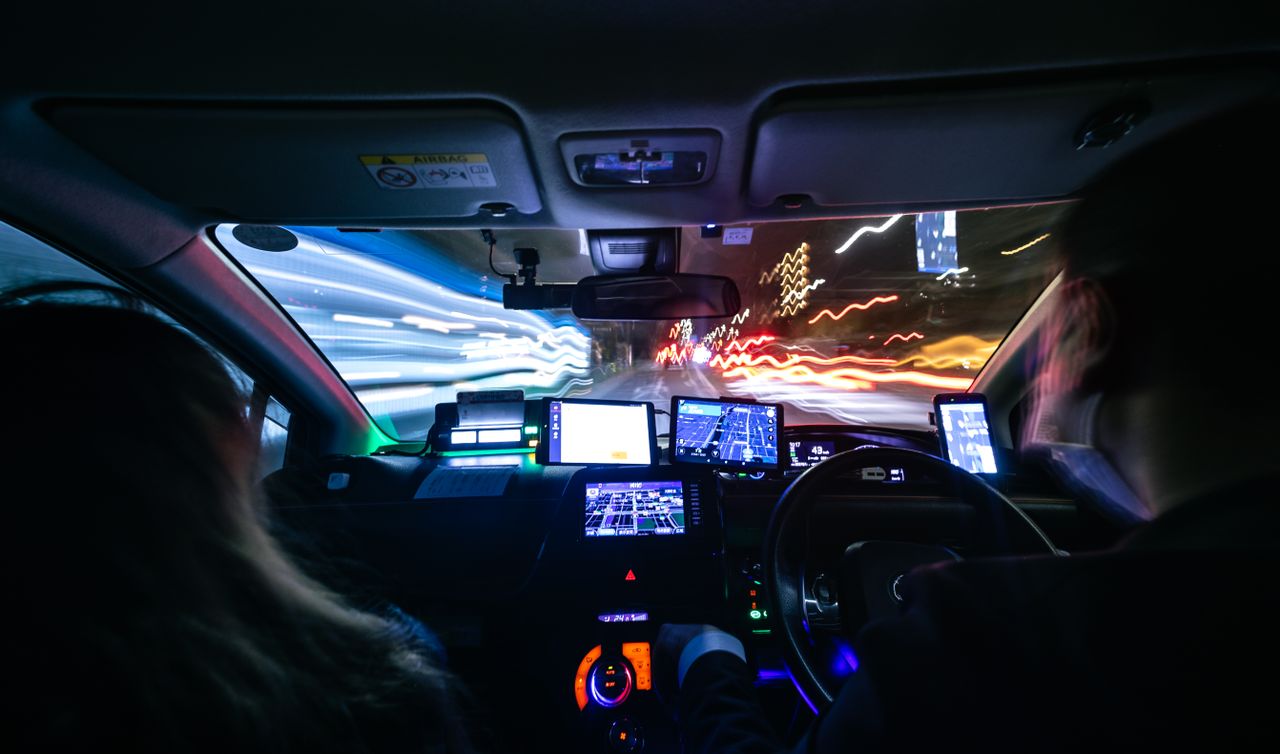 Experience the fast-paced energy of a night drive through Kyoto with vibrant city lights and motion blur.